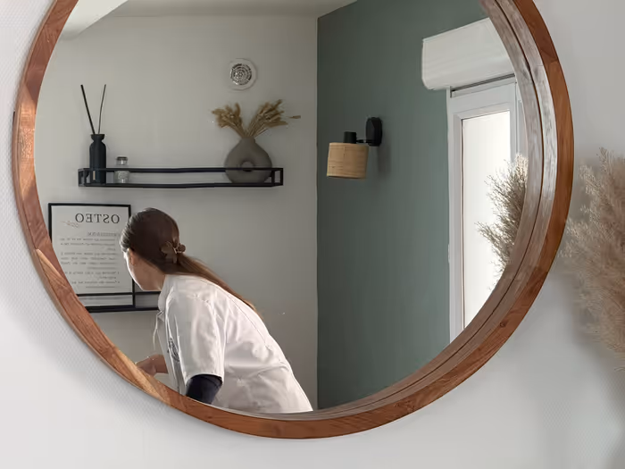 Emma Da Silva réalisant une séance d'ostéopathie vue dans un miroir