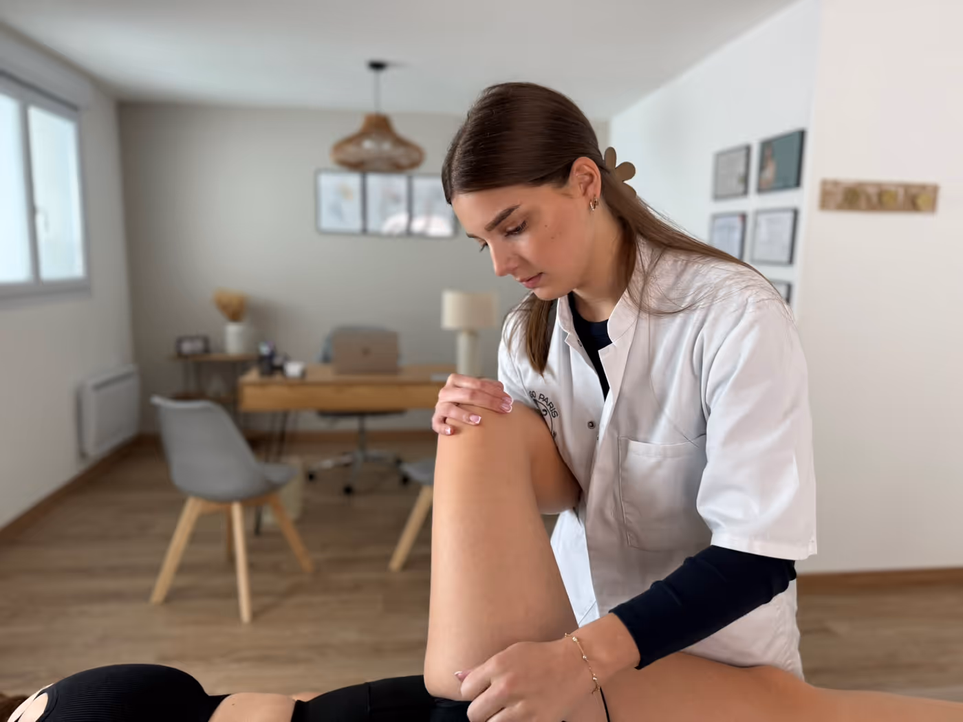 Emma Da Silva réalisant une manipulation ostéopathique sur la cuisse d'un patient